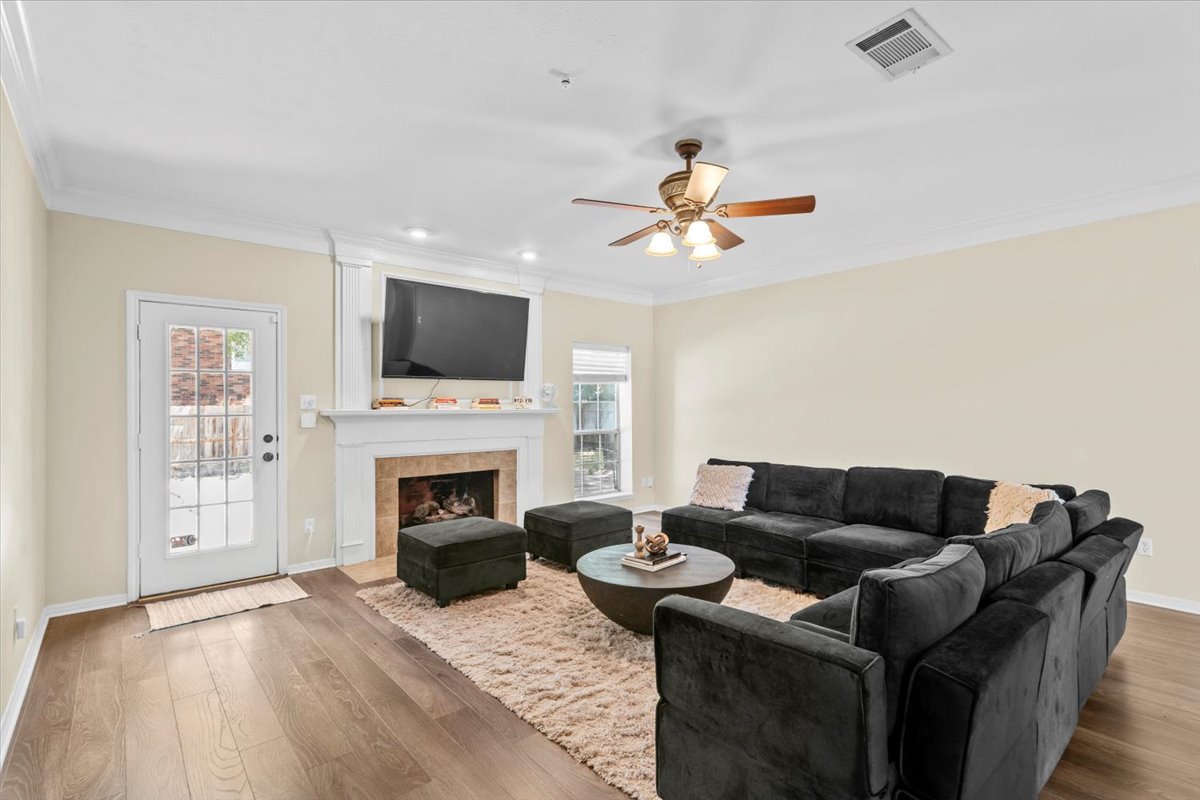 10116 Pinehurst Drive Austin, TX 78747 - Photo 11 of 37 Living area featuring wood finished floors, plenty of natural light, ornamental molding, a tile fireplace, and recessed lighting