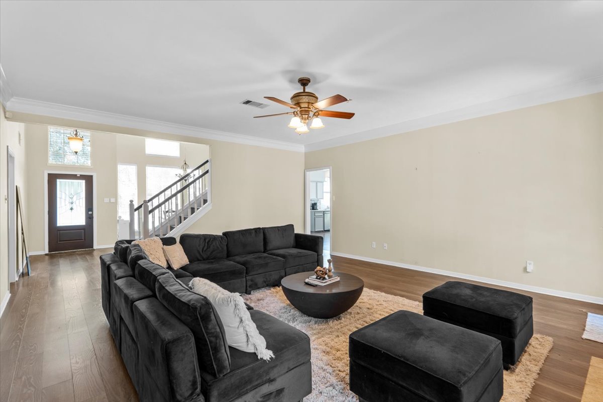 10116 Pinehurst Drive Austin, TX 78747 - Photo 12 of 37 Living room with wood finished floors, stairs, ornamental molding, and ceiling fan