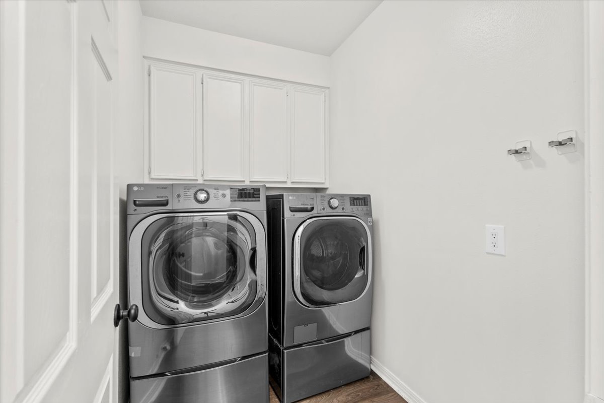 10116 Pinehurst Drive Austin, TX 78747 - Photo 14 of 37 Laundry area with cabinet space, washing machine and dryer, and wood finished floors