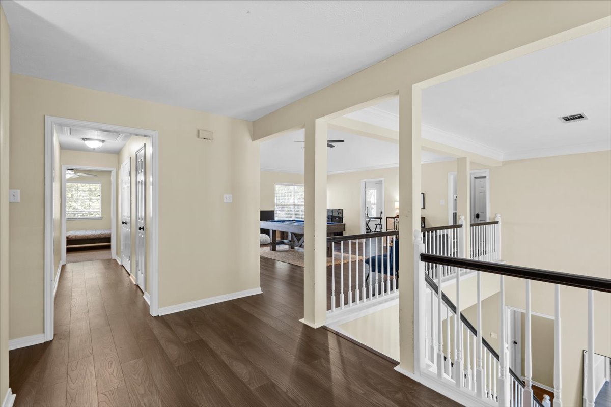 10116 Pinehurst Drive Austin, TX 78747 - Photo 20 of 37 Hall with dark wood finished floors, crown molding, and an upstairs landing