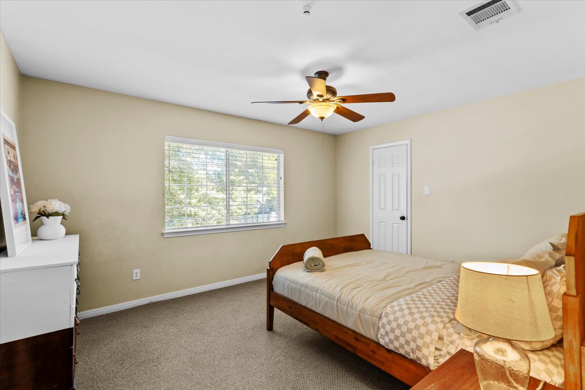 10116 Pinehurst Drive Austin, TX 78747 - Photo 21 of 37 Carpeted bedroom featuring baseboards and a ceiling fan