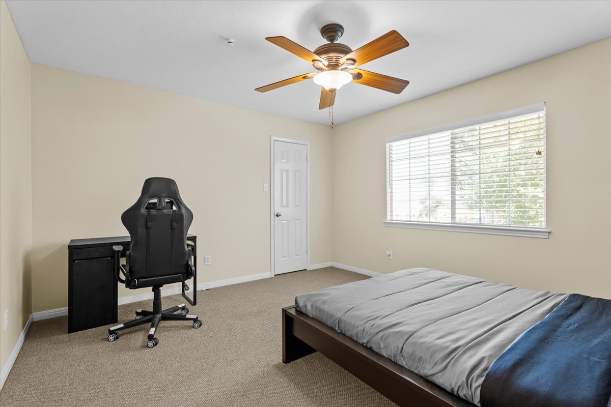 10116 Pinehurst Drive Austin, TX 78747 - Photo 24 of 37 Bedroom with carpet floors, an office area, and ceiling fan