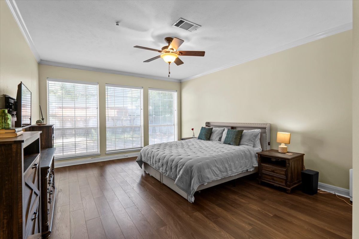 10116 Pinehurst Drive Austin, TX 78747 - Photo 29 of 37 Bedroom featuring dark wood-style flooring, crown molding, and a ceiling fan