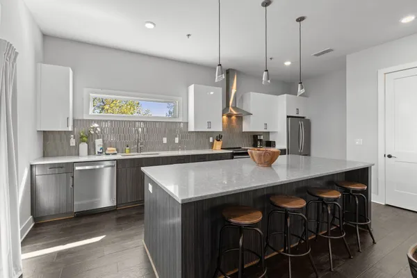 a kitchen with kitchen island a counter space a sink appliances and cabinets