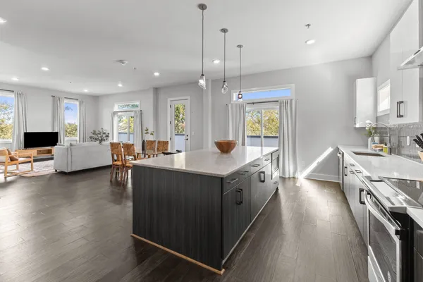 a large kitchen with stainless steel appliances kitchen island granite countertop a large island in the center
