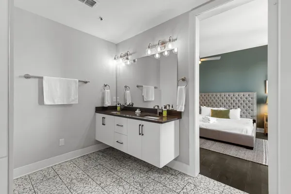 a spacious bathroom with a double vanity sink a mirror and shower