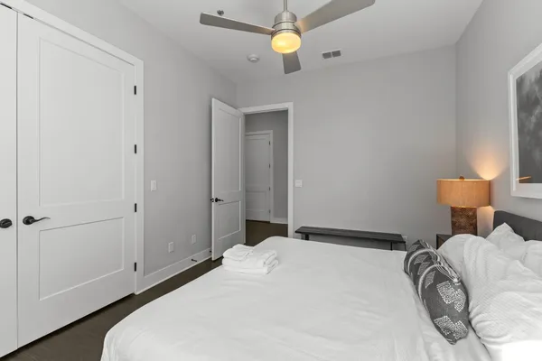 a bedroom with a bed and a lamp on the dresser