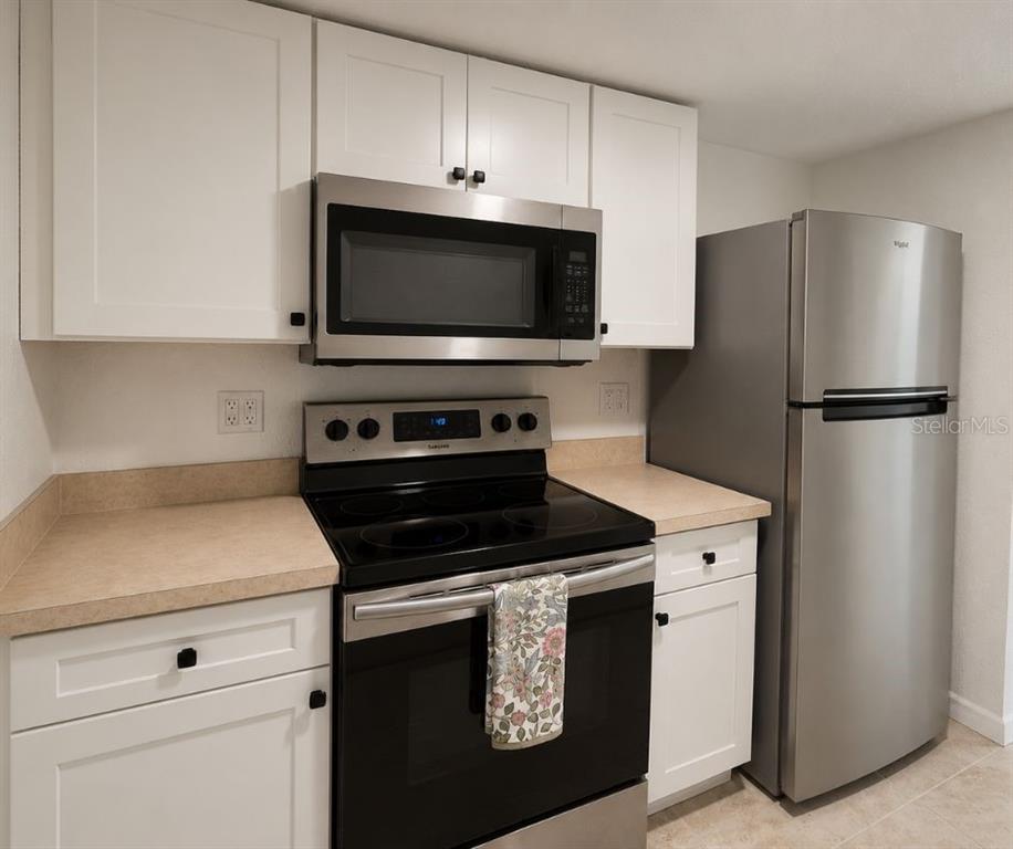 902 Lake Destiny Road, Unit C Altamonte Springs, FL 32714 - Photo 6 of 23 a kitchen with white cabinets and stainless steel appliances