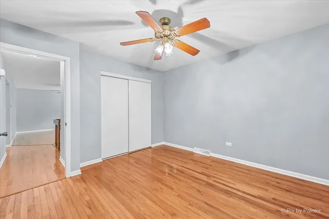 an empty room with closet and fan
