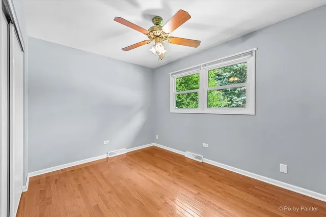 an empty room with a window and a ceiling fan