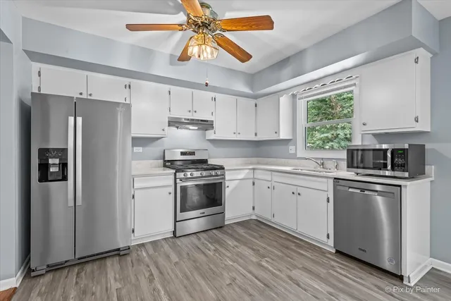 a kitchen with stainless steel appliances a refrigerator sink and stove