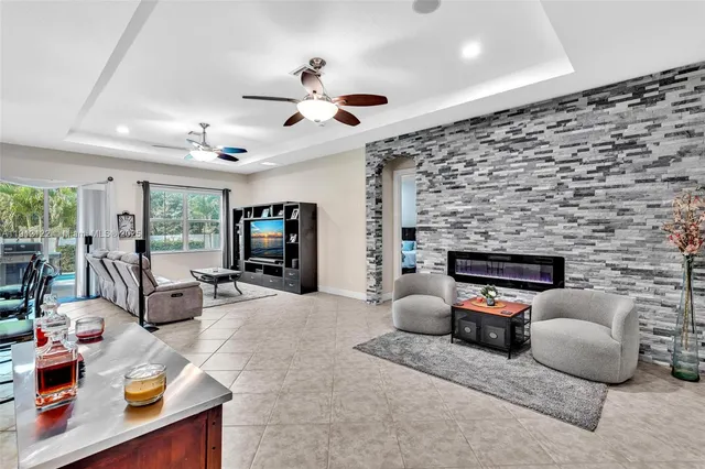a living room with furniture a ceiling fan and a window
