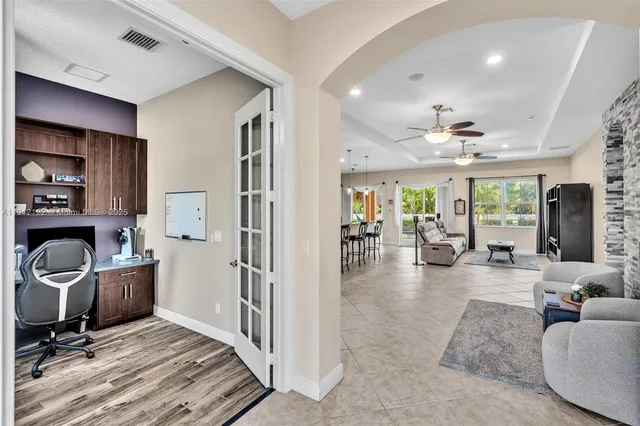 a living room with furniture a flat screen tv and floor to ceiling window