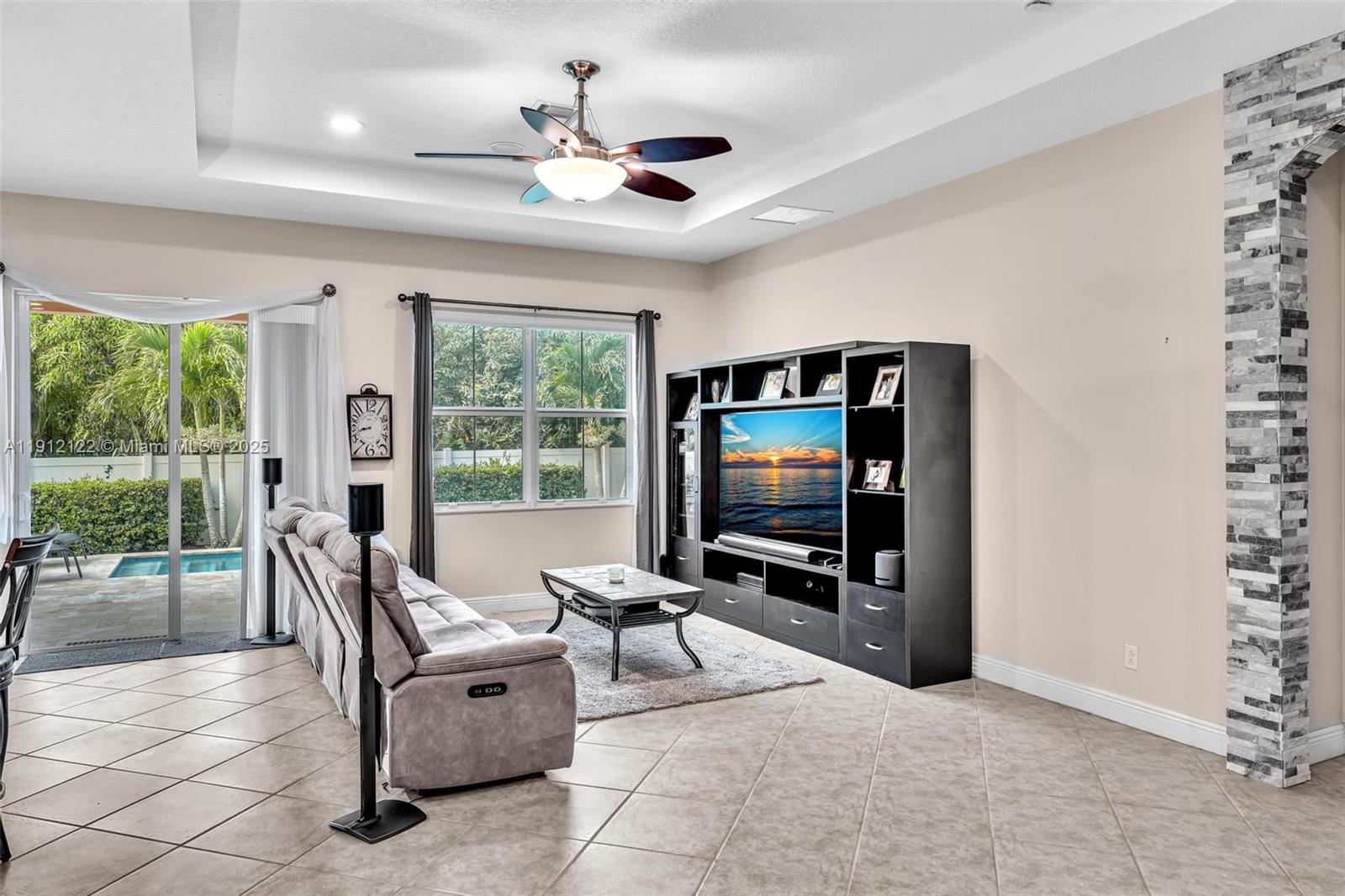 13220 Southwest 13th Street Davie, FL 33325 - Photo 21 of 65 a living room with furniture a flat screen tv and floor to ceiling window