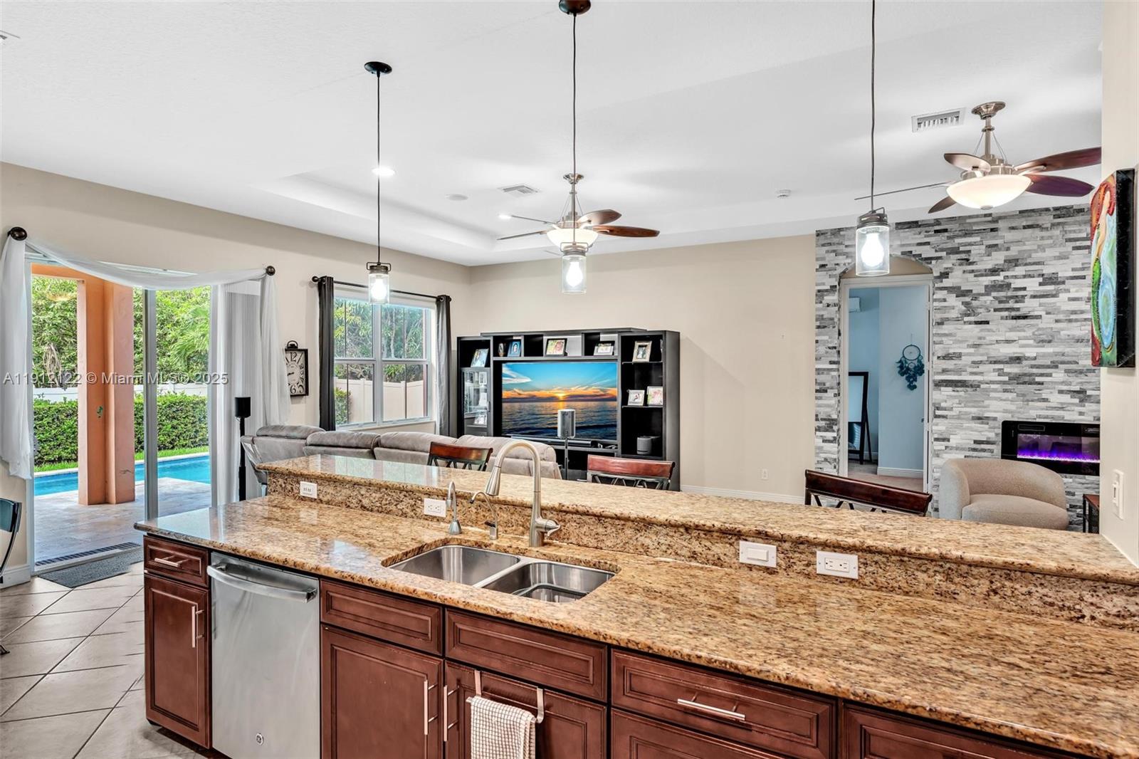 13220 Southwest 13th Street Davie, FL 33325 - Photo 29 of 65 a kitchen with kitchen island granite countertop a sink and a large window