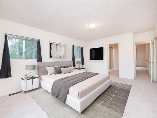 a bedroom with a large bed and a flat screen tv