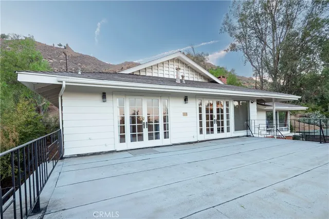 a view of a house with a window and wooden fence