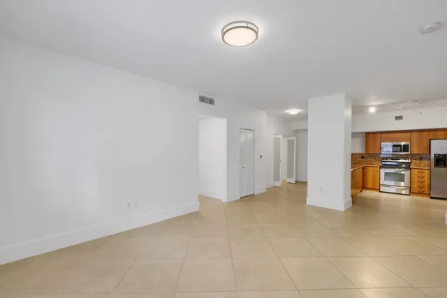 a view of an empty room with a kitchen