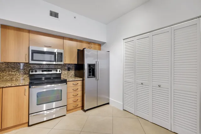 a kitchen with stainless steel appliances granite countertop a stove a refrigerator and a microwave