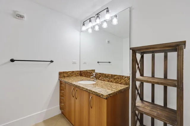 a bathroom with a granite countertop sink and a mirror