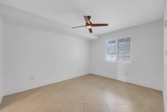 an empty room with chandelier fan