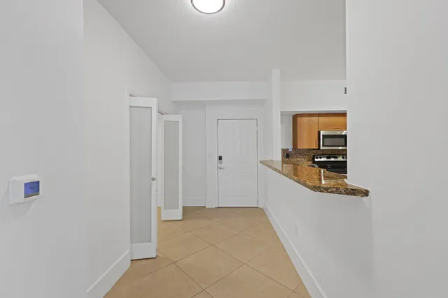 a hallway with white cabinets and white appliances