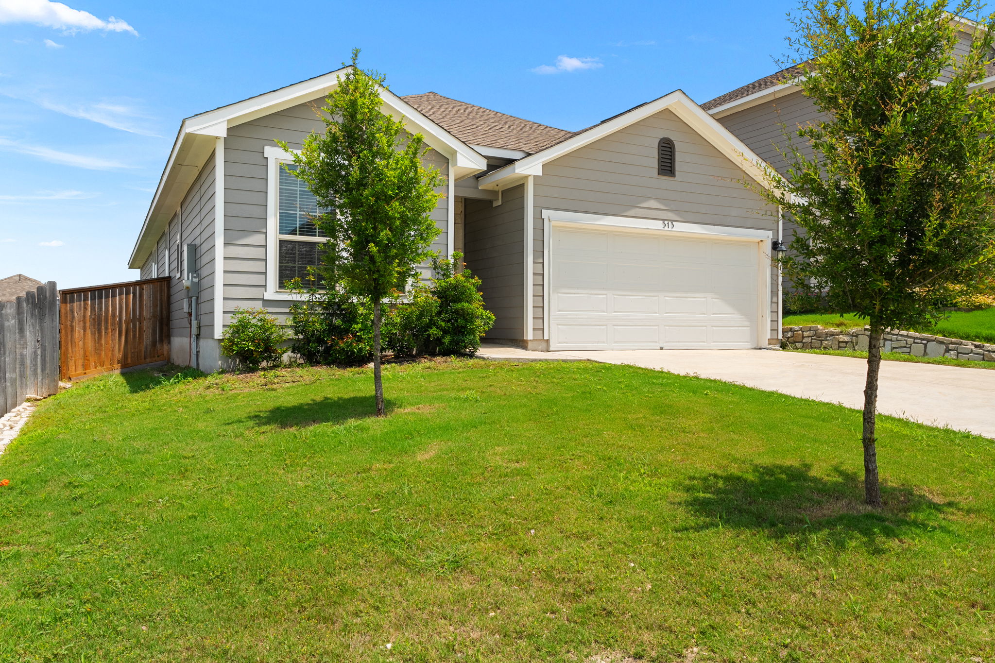 313 Mclintock Road Jarrell, TX 76537 - Photo 3 of 40 A welcoming facade with a well-maintained lawn and an attached garage awaits.