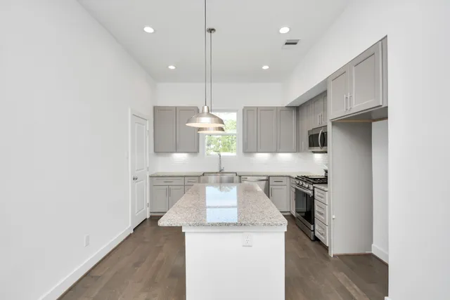 a kitchen with a sink cabinets and wooden floor
