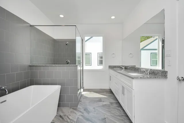 a bathroom with a granite countertop bathtub sink vanity and toilet