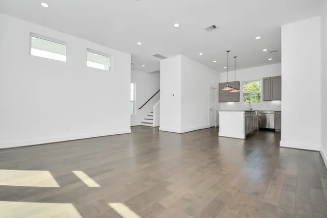 a view of a big room with wooden floor and windows