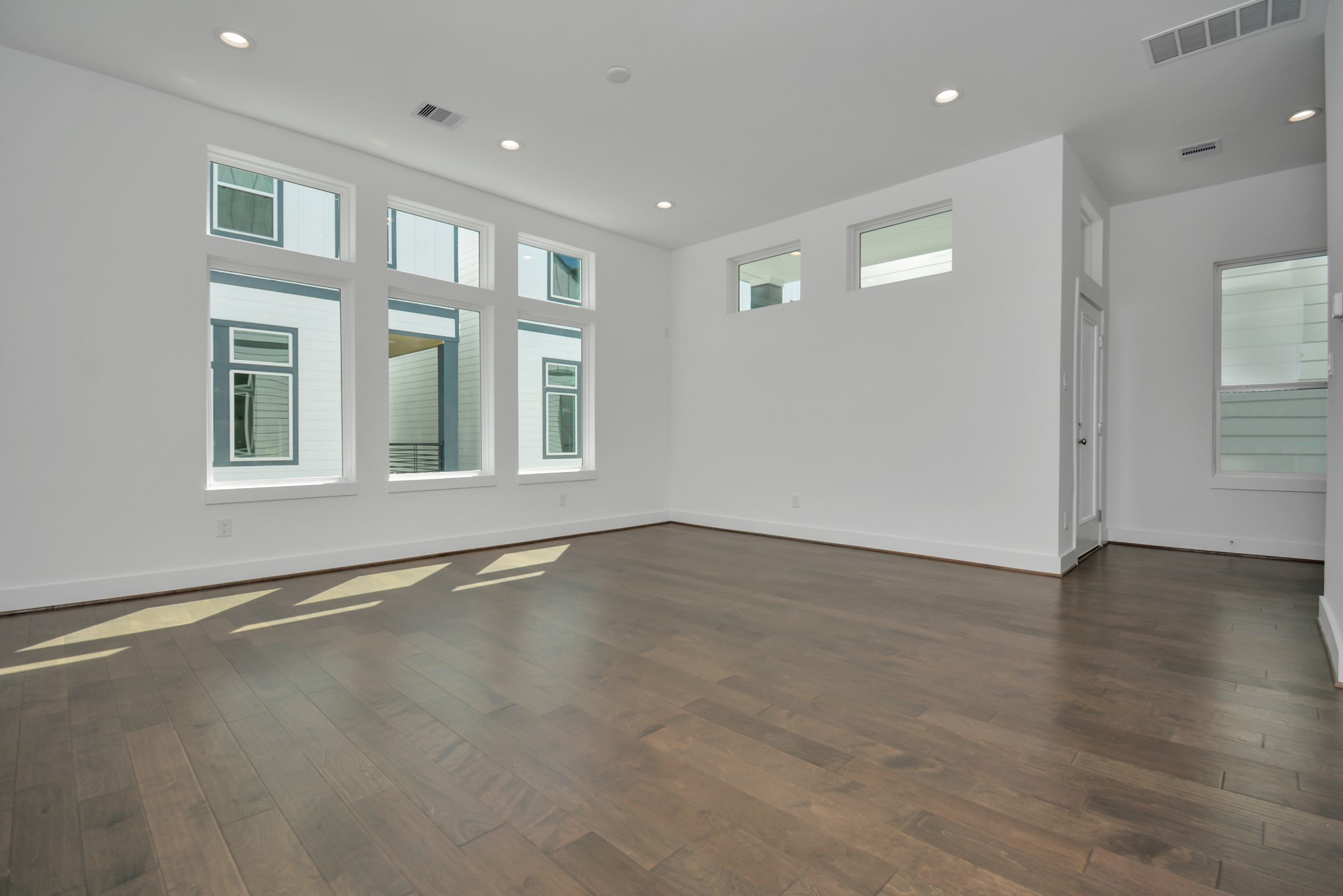 420 Janisch Road, Unit B Houston, TX 77018 - Photo 9 of 24 an empty room with wooden floor and windows