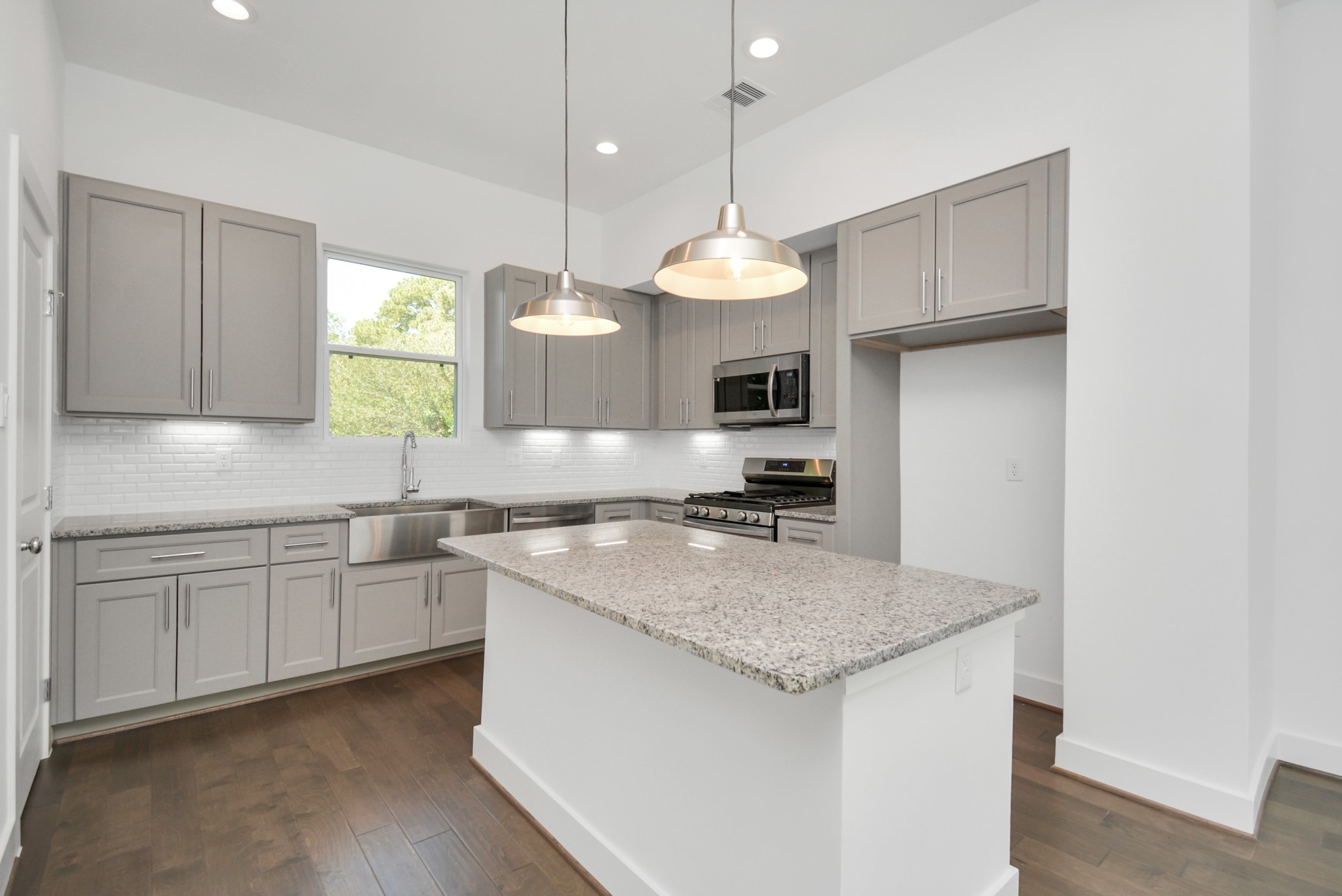 420 Janisch Road, Unit B Houston, TX 77018 - Photo 10 of 24 a kitchen with kitchen island granite countertop a stove a sink a center island and cabinets