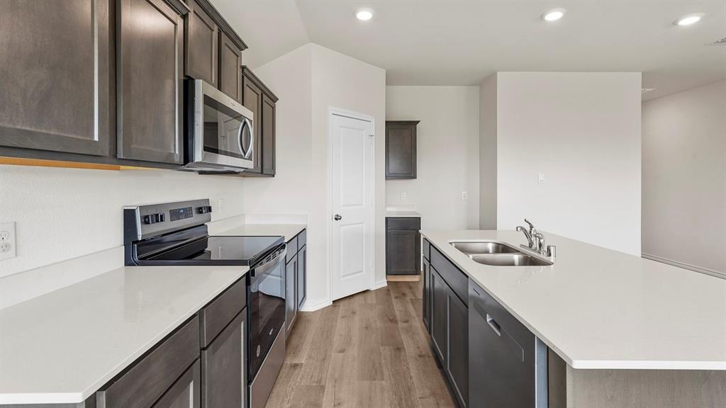 1675 Mantle Road Crandall, TX 75114 - Photo 7 of 27 Modern kitchen featuring white countertops, dark wood-finish cabinetry, stainless steel appliances, and wood-finish flooring