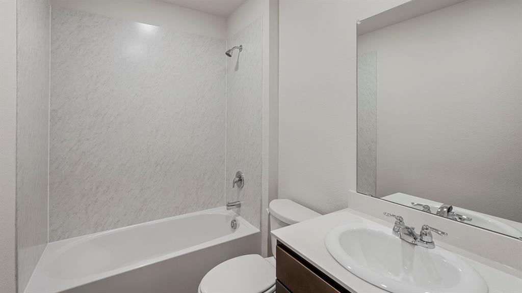 628 Dunham Road Farmersville, TX 75442 - Photo 2 of 36 White bathtub with integrated shower, chrome fixtures, a modern vanity with an integrated sink, and a large wall-mounted mirror