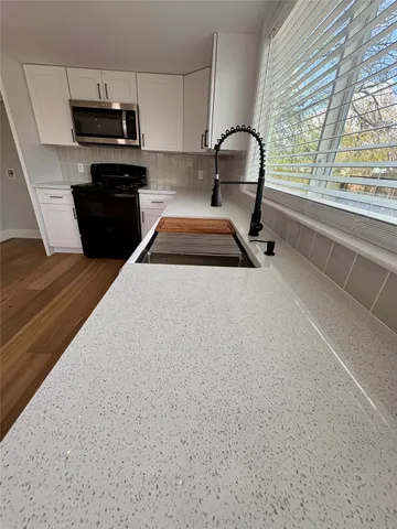 a kitchen with a stove a sink and a microwave