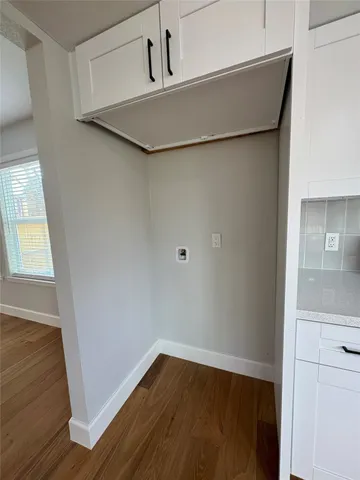 a view of a small space with wooden floor and a window