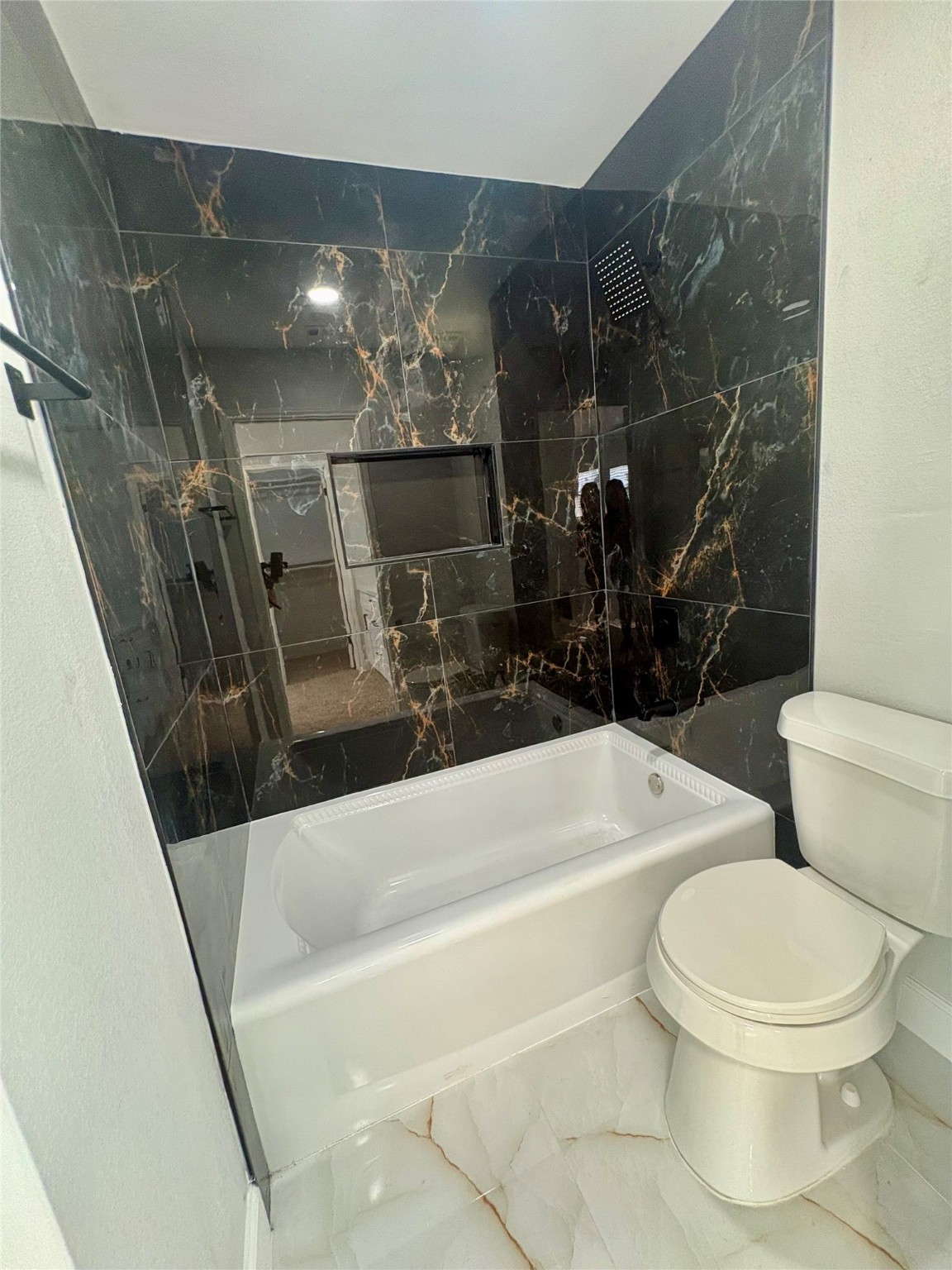 12303 Split Rail Lane Houston, TX 77071 - Photo 40 of 50 The primary bathroom has been completely renovated with sleek black wall tile, modern floor tile, a new toilet, and PEX plumbing, featuring a new shower valve and showerhead for long-term reliability and comfort.