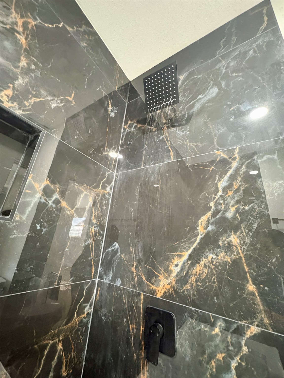 12303 Split Rail Lane Houston, TX 77071 - Photo 41 of 50 A close-up of the black tile walls highlights their bold design and modern elegance, adding a luxurious and timeless statement to the bathroom’s overall aesthetic.