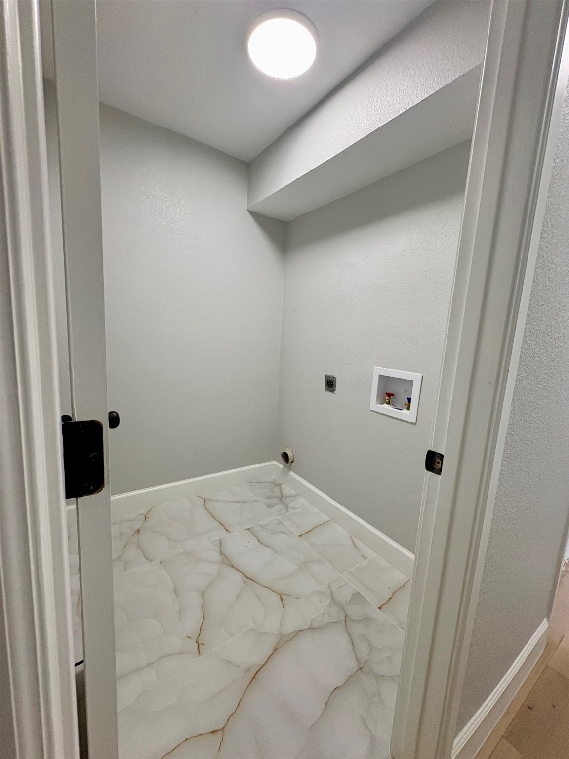 12303 Split Rail Lane Houston, TX 77071 - Photo 44 of 50 The laundry room features elegant modern tile flooring, fresh paint and texture, and updated washer and dryer connections, offering a bright, functional space designed for everyday convenience.