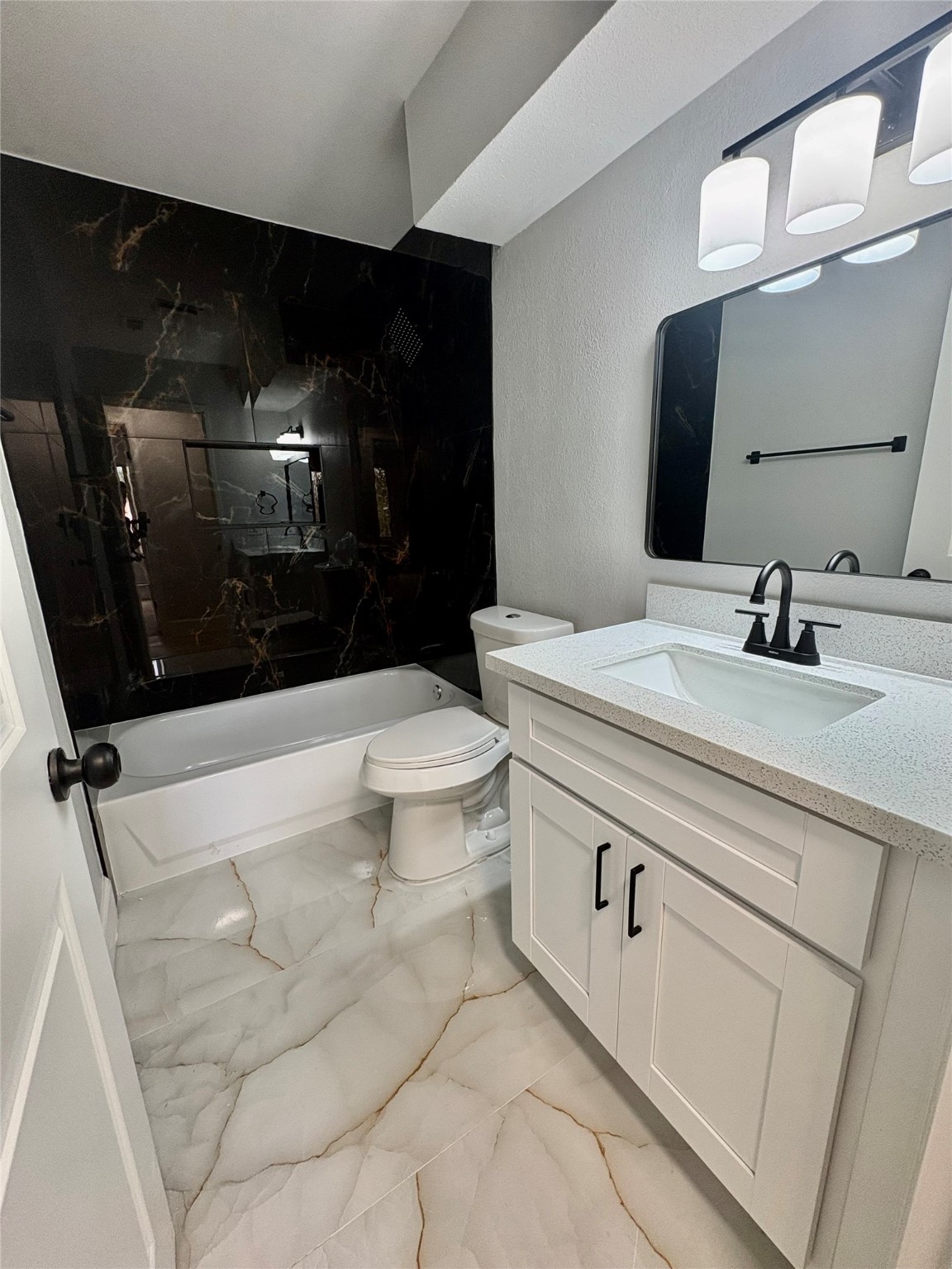 12303 Split Rail Lane Houston, TX 77071 - Photo 45 of 50 The beautifully updated guest bathroom features striking black wall tile, elegant modern floor tile, and updated fixtures that create a clean, contemporary look with timeless appeal.