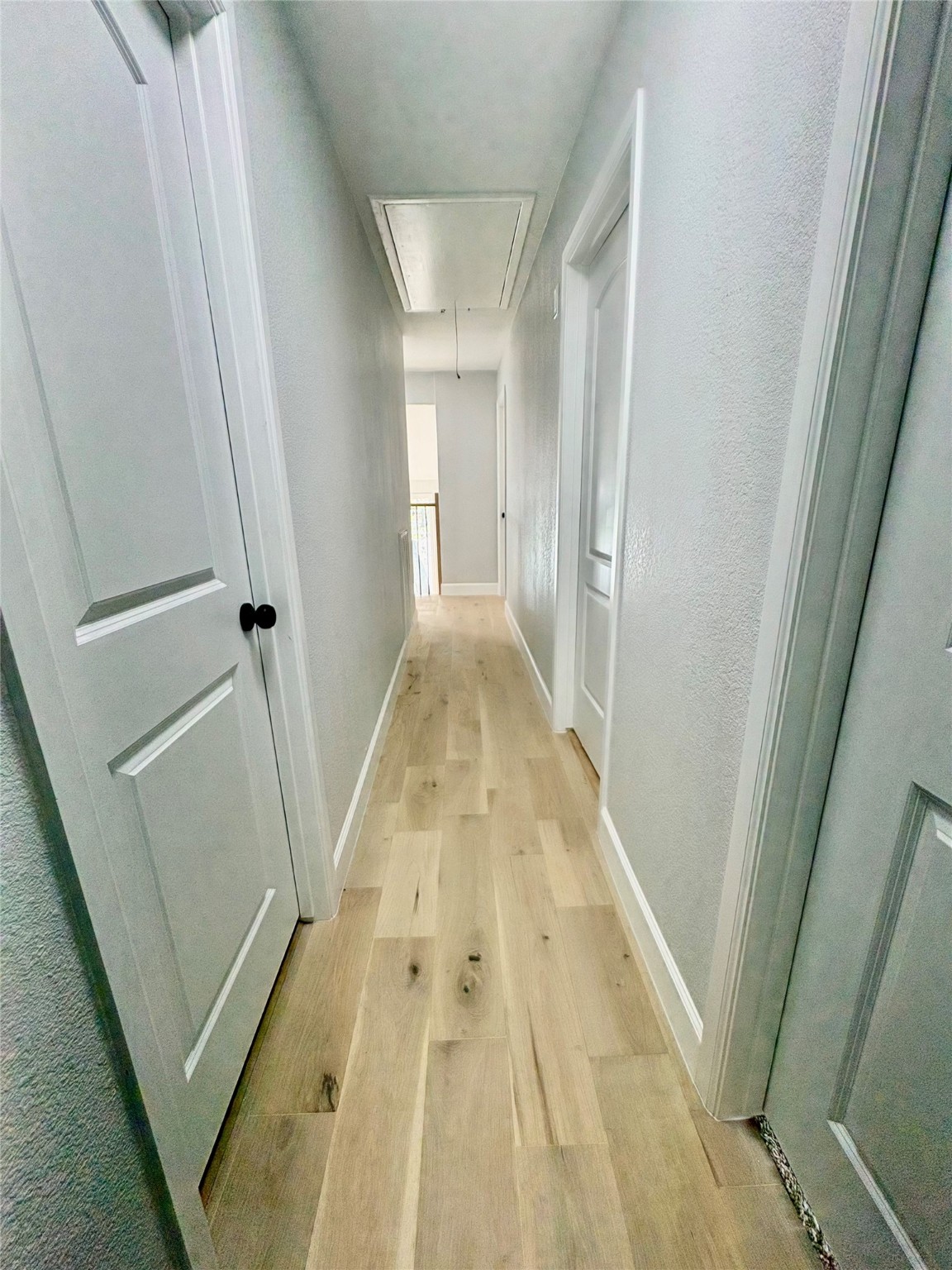 12303 Split Rail Lane Houston, TX 77071 - Photo 49 of 50 The upstairs hallway features engineered white oak flooring, fresh paint and texture, and new Roman-style doors, creating a bright and cohesive transition between the home’s beautifully updated upper-level spaces.