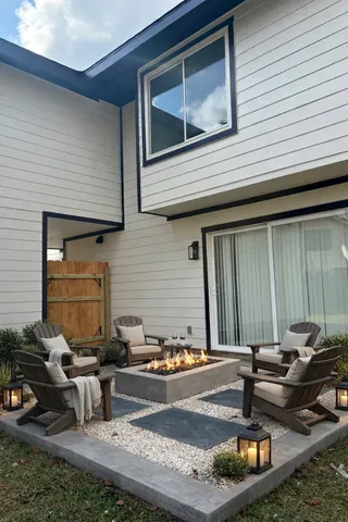a view of a house with backyard and sitting area