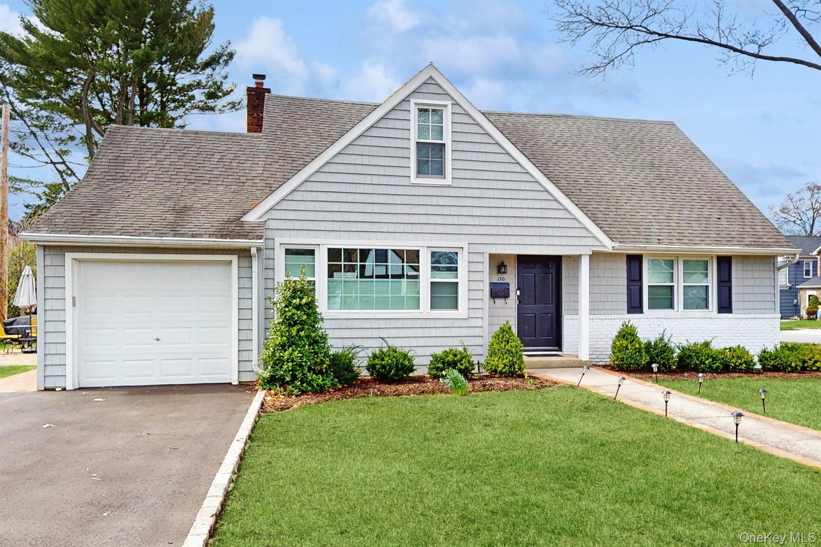 170 Wetherill Road Garden City, NY 11530 - Photo 1 of 23 View of front facade featuring an attached garage, roof with shingles, a chimney, and a front yard