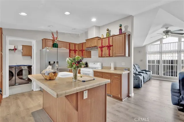 a kitchen with a stove a sink dishwasher and a refrigerator with wooden floor