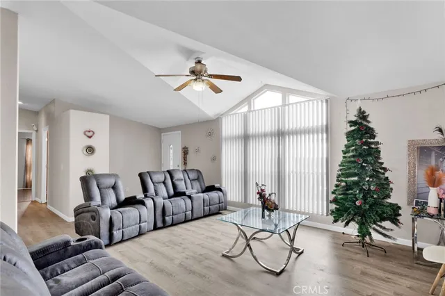 a living room with furniture a flat screen tv and a window