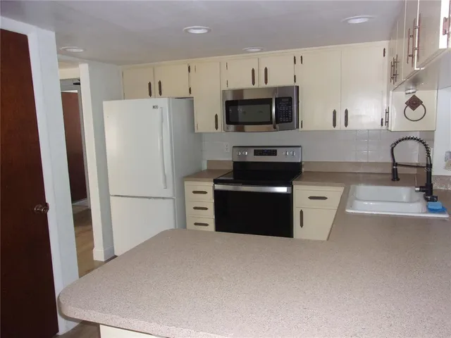 a kitchen with stainless steel appliances a refrigerator stove microwave and sink