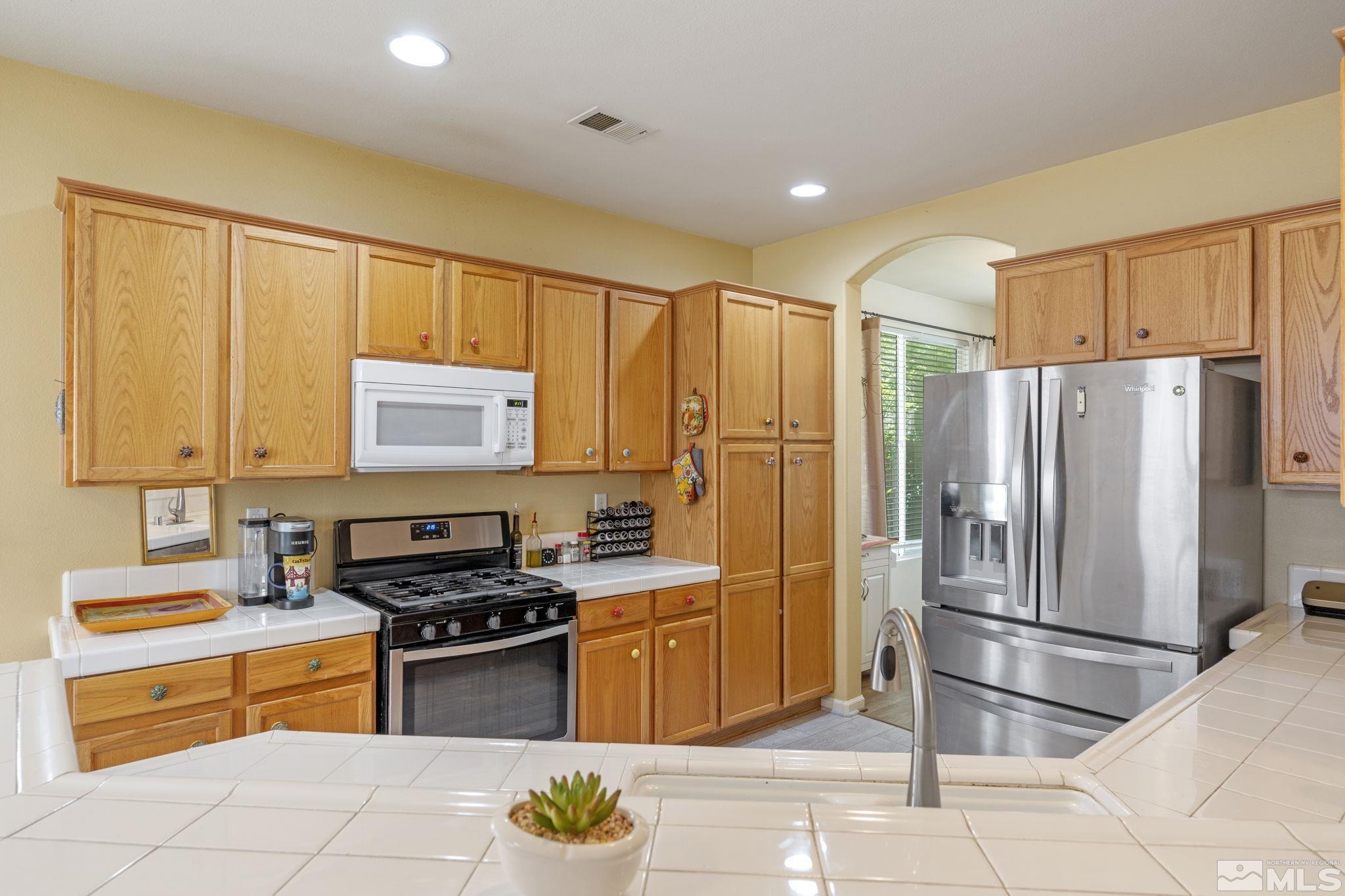 10465 Summershade Lane Reno, NV 89521 - Photo 12 of 30 a kitchen with stainless steel appliances granite countertop a refrigerator sink and stove