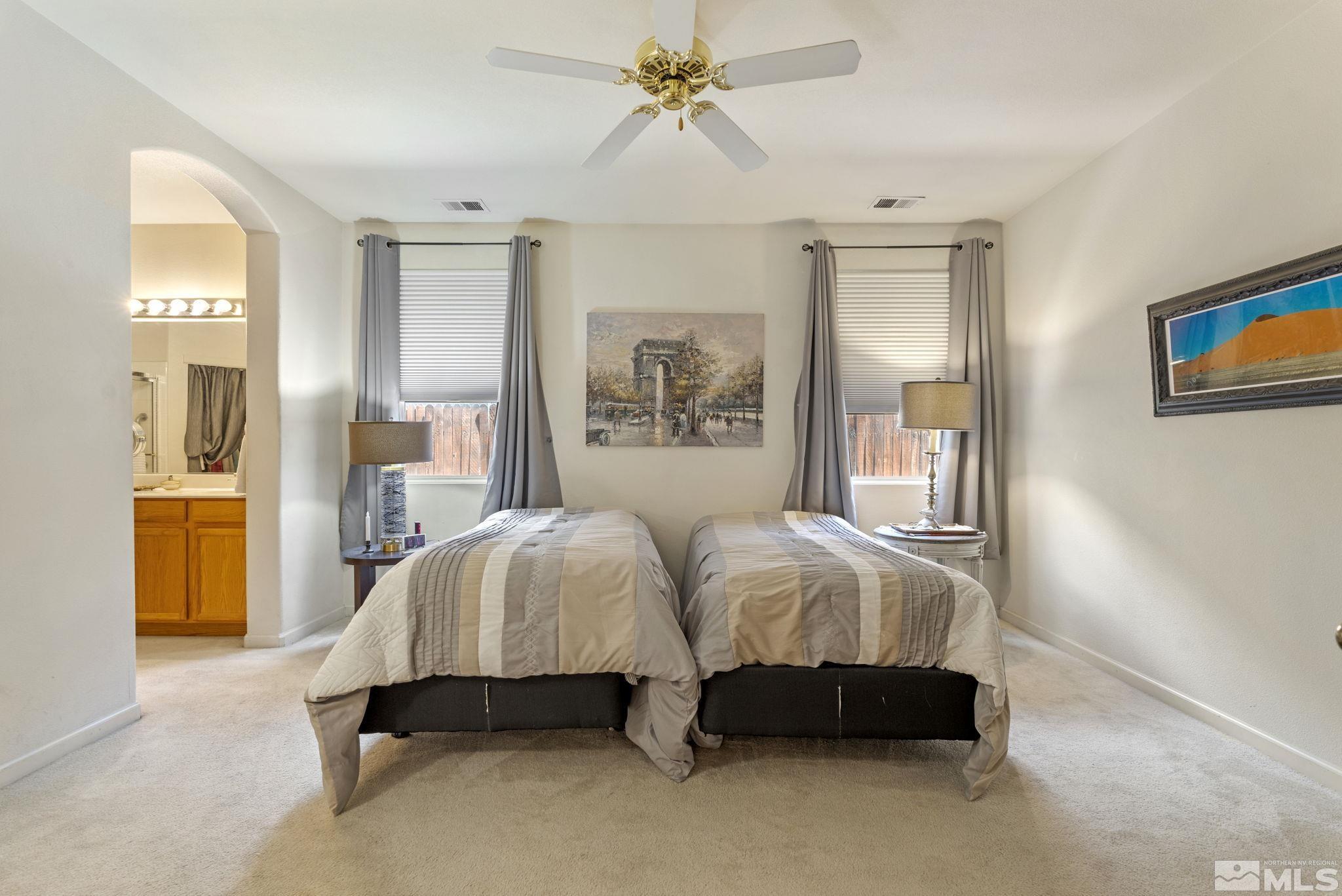 10465 Summershade Lane Reno, NV 89521 - Photo 21 of 30 a spacious bedroom with a bed and a chandelier