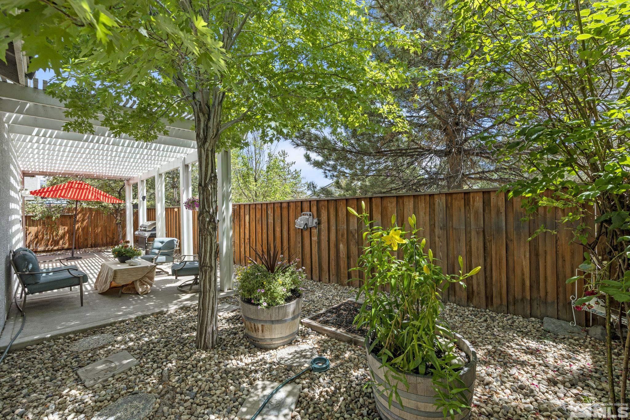10465 Summershade Lane Reno, NV 89521 - Photo 28 of 30 a view of a backyard with potted plants and large tree