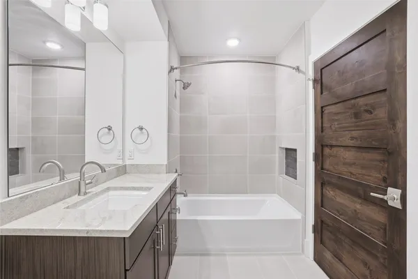 a bathroom with a granite countertop sink a mirror and a bathtub